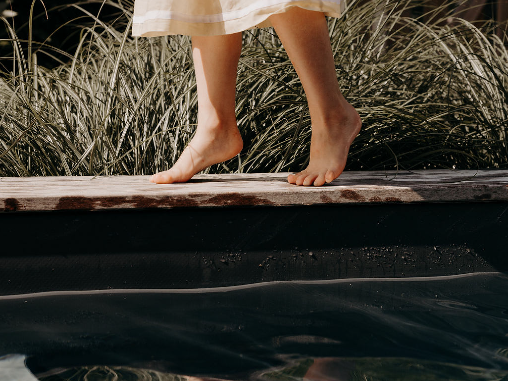 Pieds féminins sur le bord de la piscine de Chez Brens.