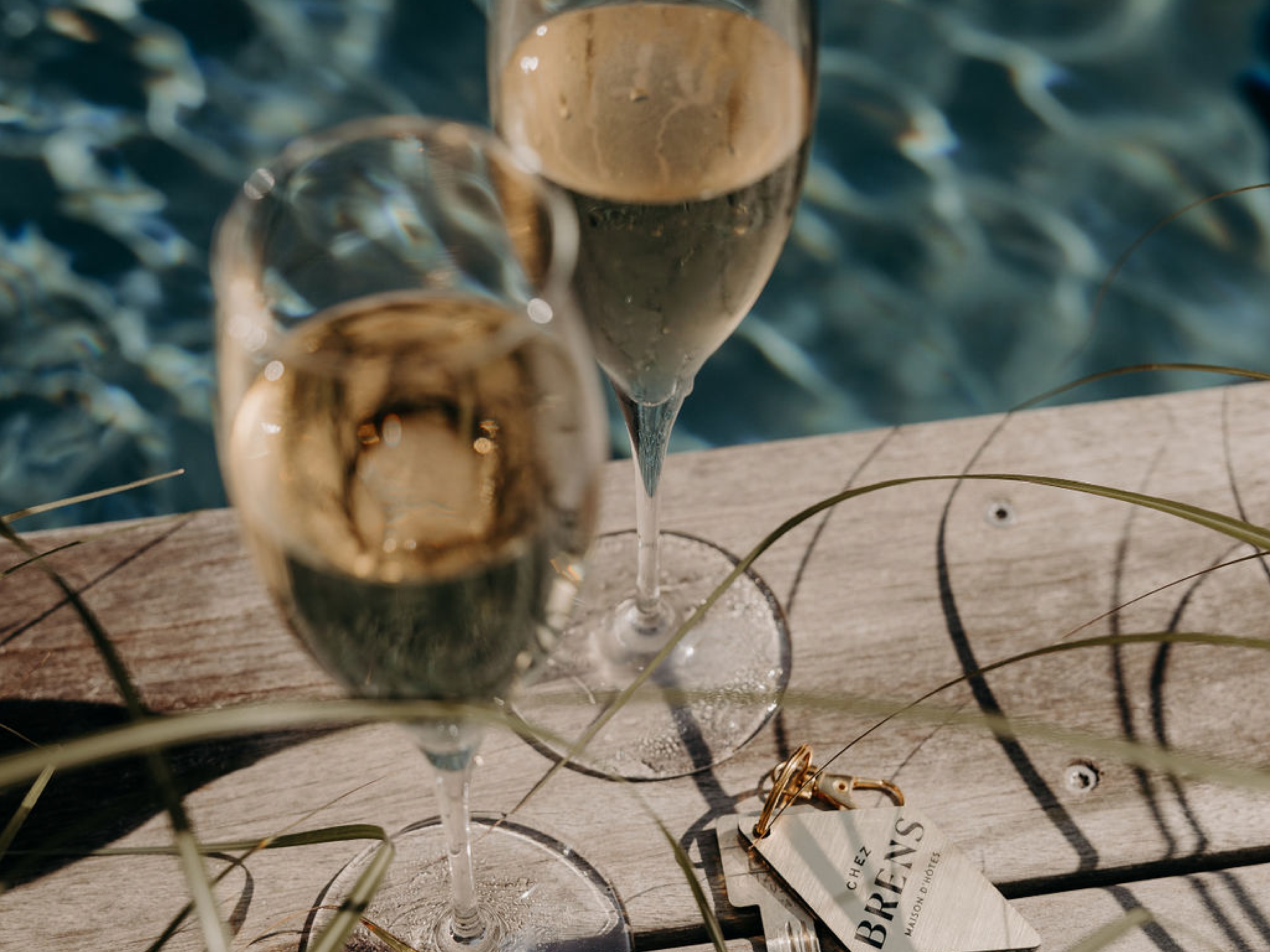 Flutes à champagne sur le bord de la piscine de Chez Brens.