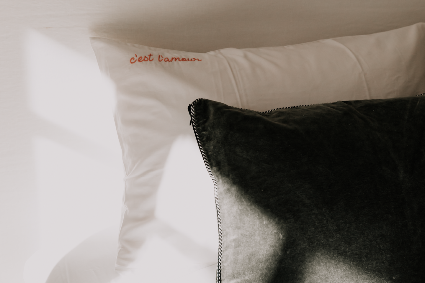 Zoom coussin lit avec inscription : c'est l'amour.